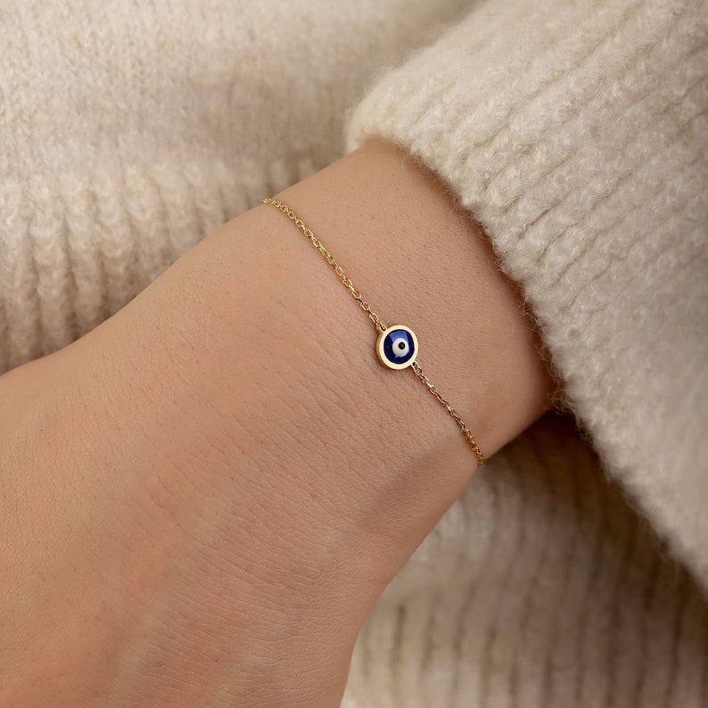 Dainty 18K gold evil eye protection bracelet with symbolic blue evil eye charm