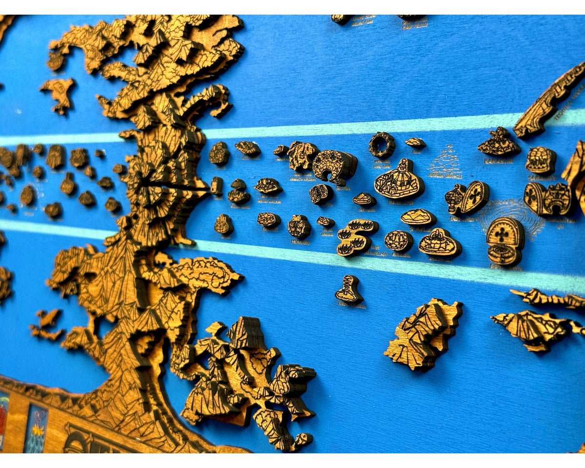 Angled close-up of brown layered wooden continent and small island pieces raised above a blue sea with light blue stripes.