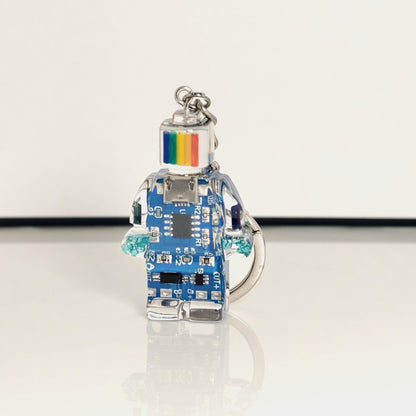 One blue circuit board robot keychain with a rainbow-striped head and silver key ring on a white background