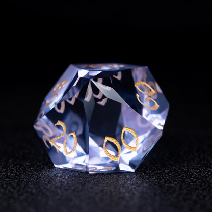 Faceted blue-violet clear percentile d10 die with gold numbers 20, 00 and 60, on a dark sparkly surface
