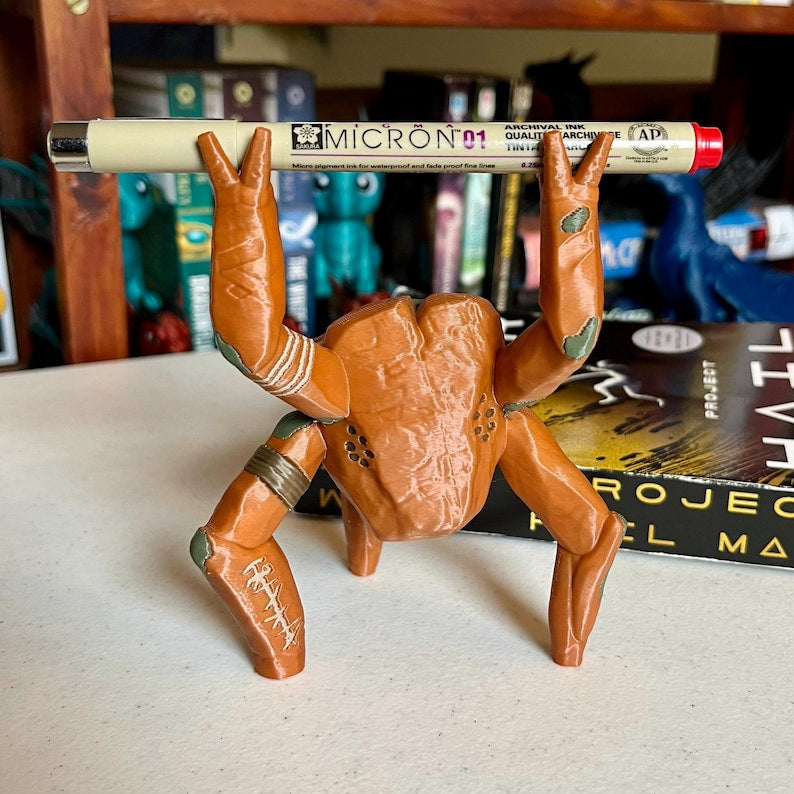 3D printed Rocky the Alien pen holder figure on a desk